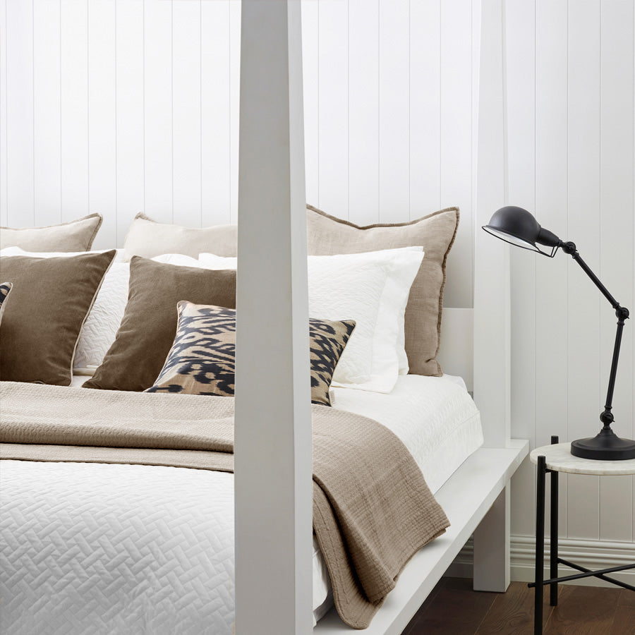 Mushroom Resort Quilted Bedspread casually draped over a modern white bed with bedside lamp – lightweight for summer, warm for winter