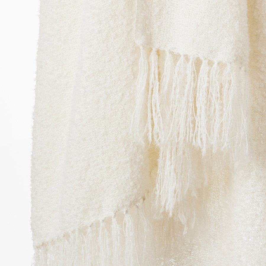 Image showcasing the Chalk Andes throw, an eco-friendly home accessory made from high-quality fleece from the Peruvian highlands. The throw features a delicate fringe, measures 150cm by 240cm, and offers both warmth and a silky touch, ideal for adding a touch of luxury and comfort to any living space.