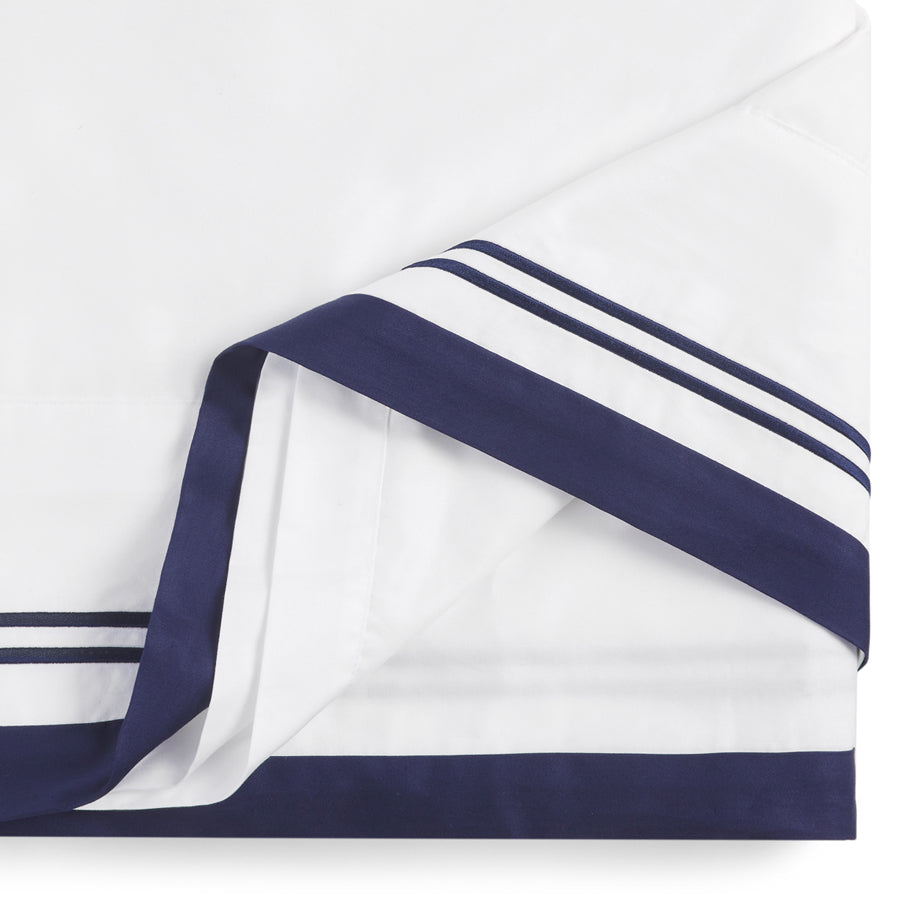 Close-up of Manhattan Luxury Pillowcases and Sheet Set by Flaxfield Linen, featuring crisp white 400TC cotton sateen, navy header, and satin-stitch embroidery