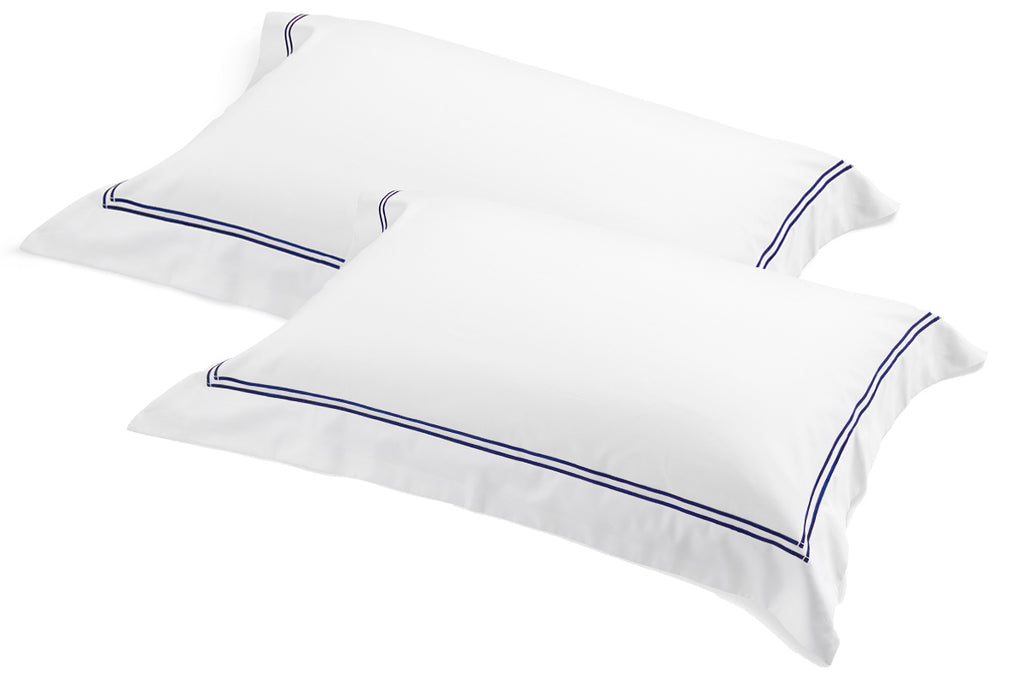 Pair of white pillowcases featuring navy satin-stitch embroidery on the border