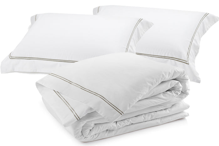 Angled view of Classique Pewter duvet cover set showing embroidered edges and smooth cotton sateen finish.