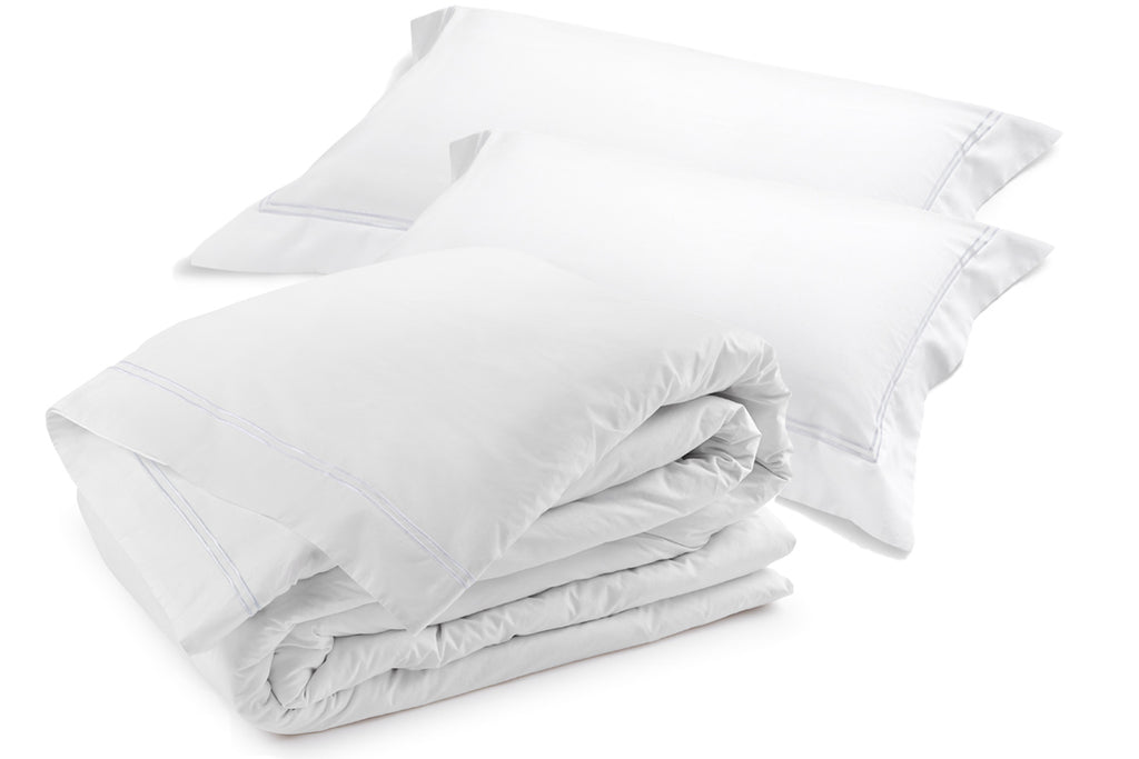Classique white duvet cover set with dual satin-stitch embroidery, stacked with matching pillowcases.