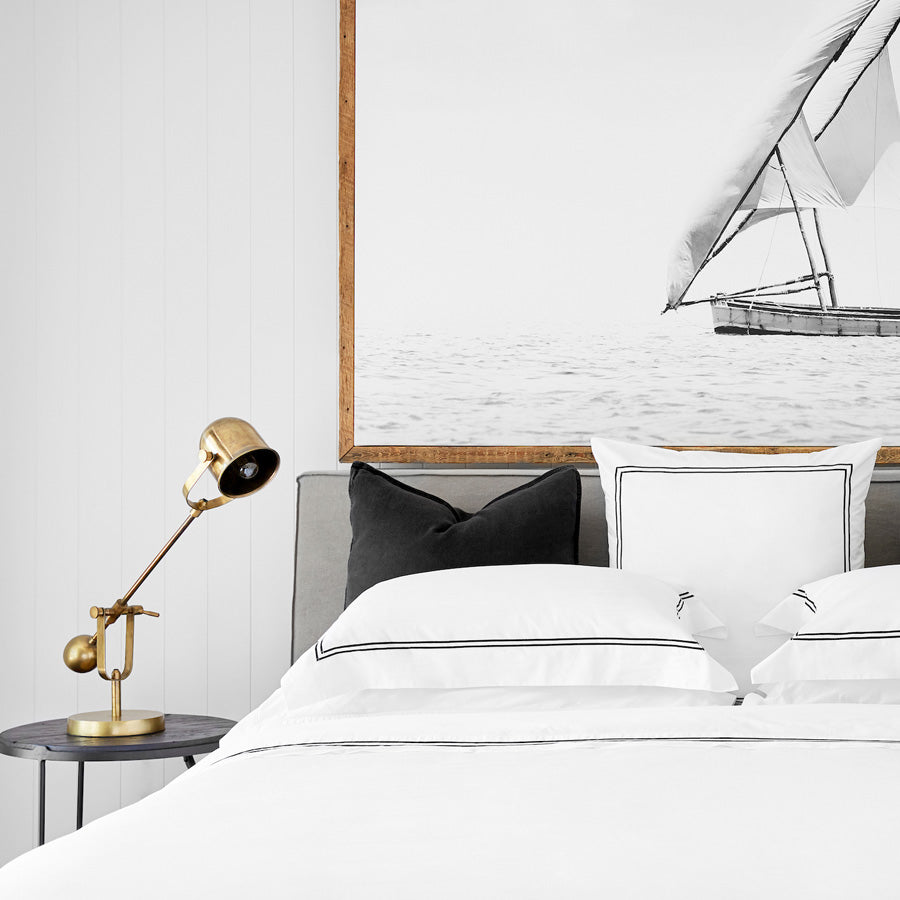 White Classique duvet cover set styled on a bed with dual satin-stitch detailing in a modern bedroom setting